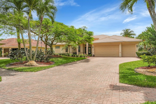4450 SW Long Bay Dr, Palm City, FL 34990 - view of front facade with stucco siding, an attached garage, decorative driveway, and a tiled roof