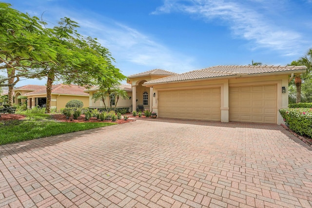 4450 SW Long Bay Dr, Palm City, FL 34990 - view of front of house with decorative driveway, stucco siding, an attached garage, and a tiled roof