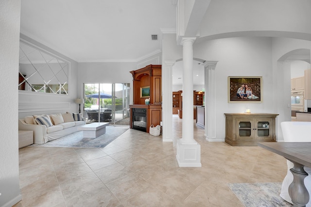4450 SW Long Bay Dr, Palm City, FL 34990 - living room with crown molding, arched walkways, light tile patterned floors, a glass covered fireplace, and decorative columns