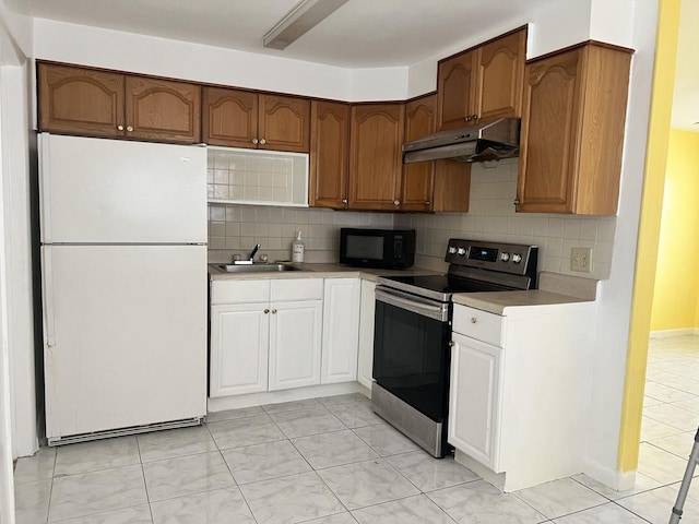 5042 Eadie Pl, West Palm Beach, FL 33407 - kitchen featuring freestanding refrigerator, electric range, under cabinet range hood, black microwave, and a sink