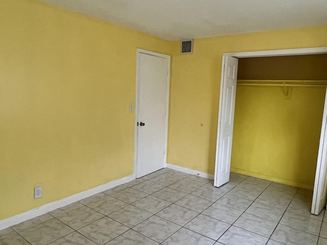 5042 Eadie Pl, West Palm Beach, FL 33407 - unfurnished bedroom with a closet, light tile patterned floors, and baseboards