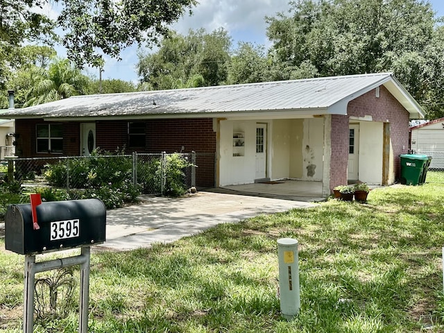 3595 SW 19th St, Okeechobee, FL 34974 - ranch-style house featuring a carport, metal roof, driveway, and brick siding