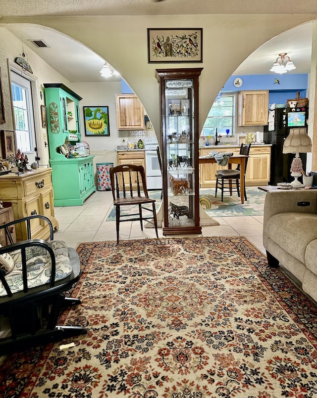 3595 SW 19th St, Okeechobee, FL 34974 - living area featuring arched walkways, light tile patterned floors, plenty of natural light, a chandelier, and a textured ceiling