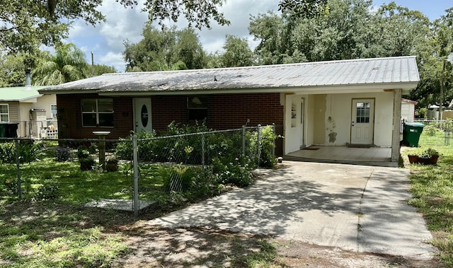 3595 SW 19th St, Okeechobee, FL 34974 - ranch-style house with a fenced front yard, brick siding, metal roof, and a porch