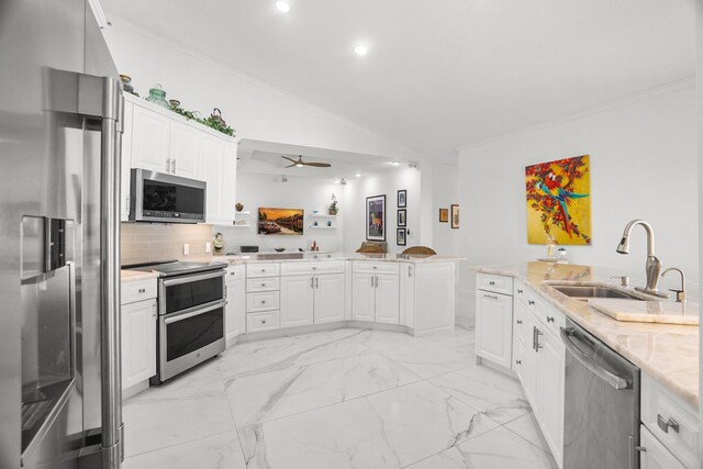 1680 SW 16th St, Boca Raton, FL 33486 - kitchen with stainless steel appliances, a peninsula, ornamental molding, lofted ceiling, and a ceiling fan