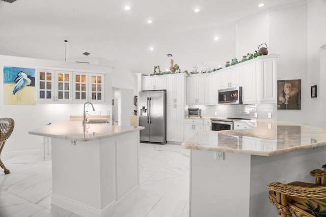 1680 SW 16th St, Boca Raton, FL 33486 - kitchen featuring stainless steel appliances, light marble finish floors, a peninsula, a breakfast bar area, and recessed lighting