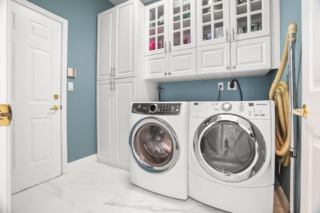 1680 SW 16th St, Boca Raton, FL 33486 - laundry area with cabinet space, marble look tiles, and separate washer and dryer