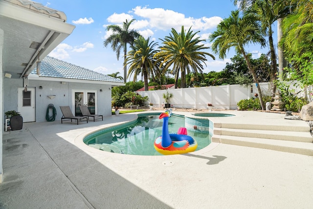 1680 SW 16th St, Boca Raton, FL 33486 - view of swimming pool with french doors, a patio area, a fenced backyard, and a pool with connected hot tub