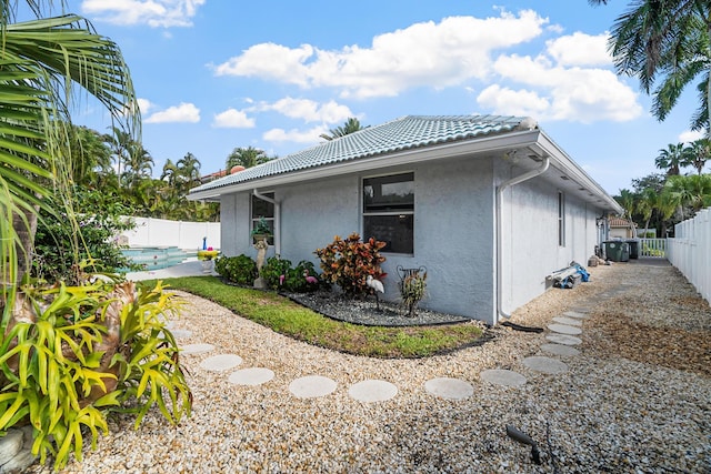 1680 SW 16th St, Boca Raton, FL 33486 - view of property exterior with a tiled roof, stucco siding, and a fenced backyard
