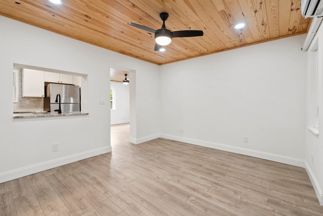 677 NE Alice St, Jensen Beach, FL 34957 - unfurnished room featuring ceiling fan, wooden ceiling, an AC wall unit, light wood-type flooring, and baseboards