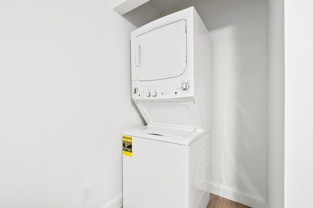677 NE Alice St, Jensen Beach, FL 34957 - laundry area with stacked washer / drying machine, baseboards, and wood finished floors