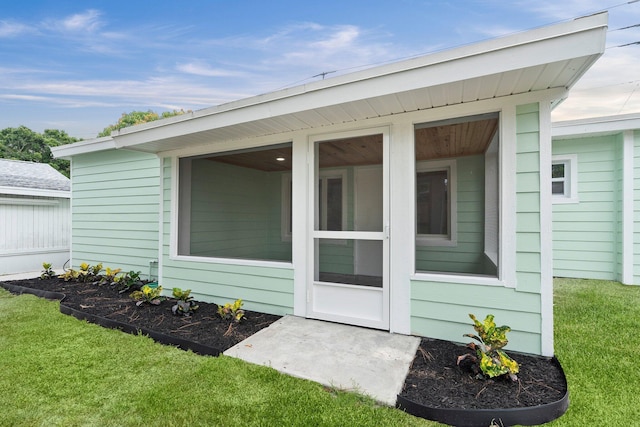 677 NE Alice St, Jensen Beach, FL 34957 - view of exterior entry featuring a lawn
