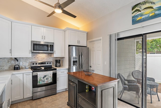 202 Lakewood Dr Unit 11C, Jupiter, FL 33458 - kitchen featuring appliances with stainless steel finishes, lofted ceiling, backsplash, white cabinets, and light tile patterned floors