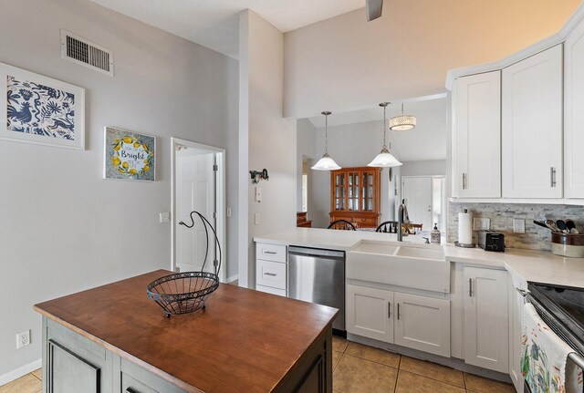 202 Lakewood Dr Unit 11C, Jupiter, FL 33458 - kitchen with appliances with stainless steel finishes, a high ceiling, tasteful backsplash, light tile patterned flooring, and wood counters
