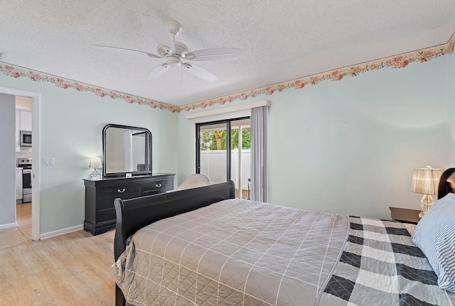 202 Lakewood Dr Unit 11C, Jupiter, FL 33458 - bedroom featuring light wood-style flooring, a textured ceiling, a ceiling fan, and baseboards