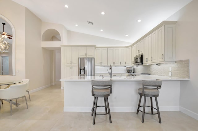 13209 Alhambra Lake Cir, Delray Beach, FL 33446 - kitchen featuring stainless steel appliances, a sink, a peninsula, a kitchen bar, and recessed lighting