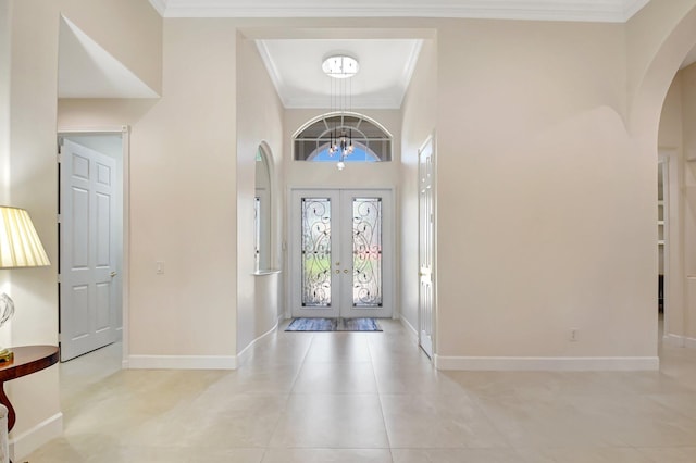 13209 Alhambra Lake Cir, Delray Beach, FL 33446 - entrance foyer with arched walkways, french doors, a chandelier, baseboards, and ornamental molding
