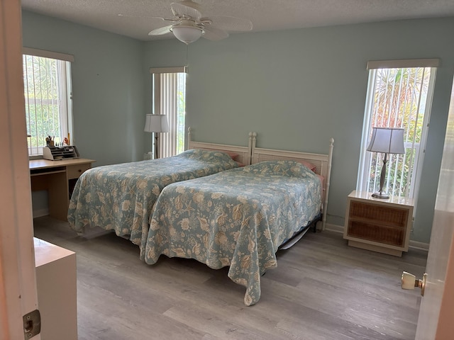 5178 Privet Pl Unit D, Delray Beach, FL 33484 - bedroom featuring wood finished floors, multiple windows, a textured ceiling, and a ceiling fan