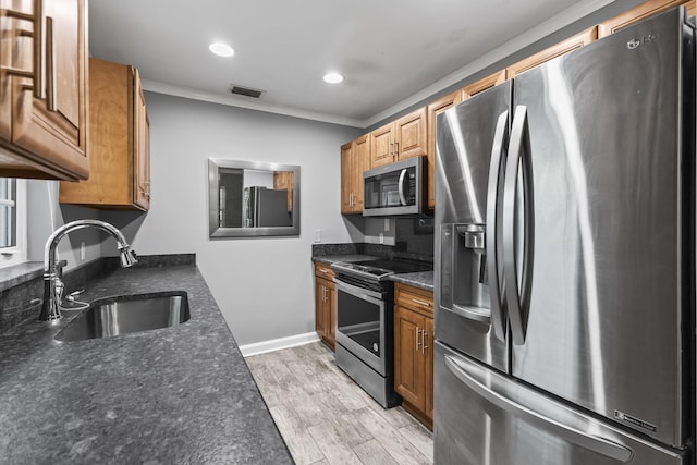 8 Vista Palm Ln Unit 103, Vero Beach, FL 32962 - kitchen with stainless steel appliances, a sink, light wood-type flooring, brown cabinets, and recessed lighting
