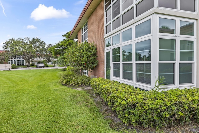 8 Vista Palm Ln Unit 103, Vero Beach, FL 32962 - view of home's exterior with brick siding and a lawn