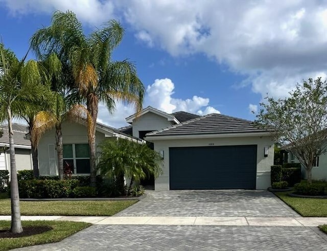 10876 SW Sunray St, Port Saint Lucie, FL 34987 - ranch-style home featuring decorative driveway, a garage, stucco siding, and a tile roof