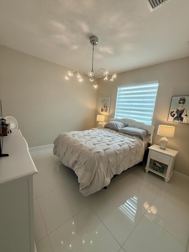 10876 SW Sunray St, Port Saint Lucie, FL 34987 - bedroom with a textured ceiling, a chandelier, light tile patterned floors, and baseboards