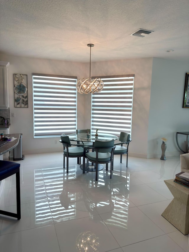 10876 SW Sunray St, Port Saint Lucie, FL 34987 - dining area featuring a chandelier, a textured ceiling, and light tile patterned floors