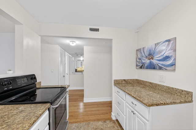3540 S Ocean Blvd Unit 610, South Palm Beach, FL 33480 - kitchen with range with electric cooktop, white cabinets, baseboards, light wood-type flooring, and light stone countertops