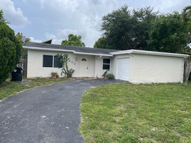 405 SW 77th Ave, North Lauderdale, FL 33068 - ranch-style home with stucco siding, an attached garage, driveway, and a front yard