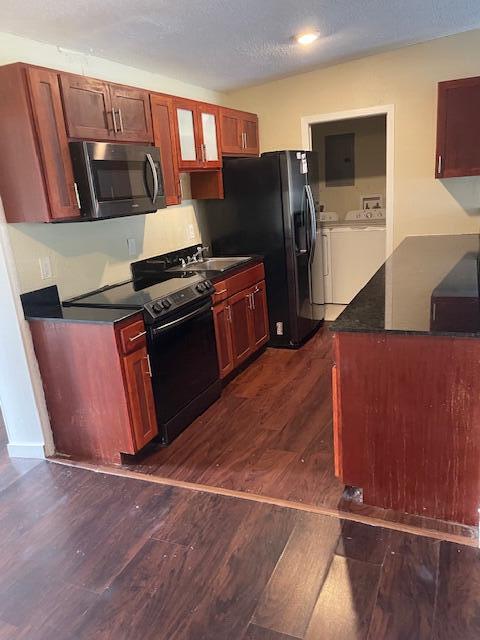 405 SW 77th Ave, North Lauderdale, FL 33068 - kitchen with black appliances, washing machine and dryer, dark wood finished floors, dark countertops, and a sink