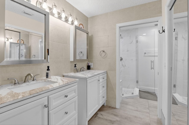 11080 Lakeaire Cir, Boca Raton, FL 33498 - full bath with tile walls, a marble finish shower, two vanities, a textured ceiling, and wood finished floors