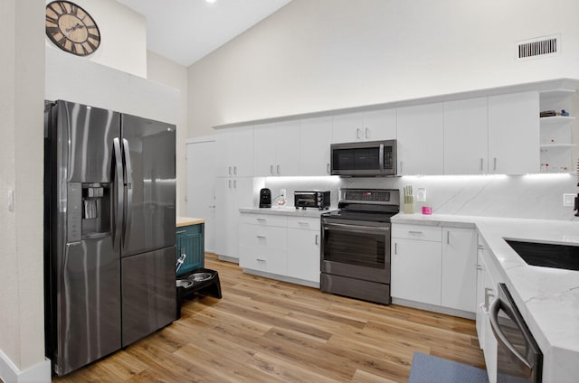 11080 Lakeaire Cir, Boca Raton, FL 33498 - kitchen with stainless steel appliances, open shelves, light wood-type flooring, decorative backsplash, and white cabinetry