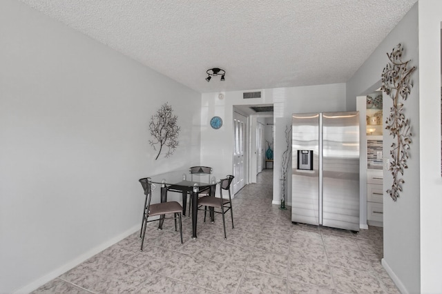 1116 Cambridge E Unit E, Deerfield Beach, FL 33442 - dining area featuring a textured ceiling and baseboards