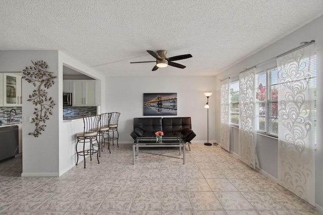 1116 Cambridge E Unit E, Deerfield Beach, FL 33442 - living room featuring a ceiling fan and a textured ceiling