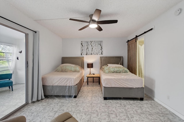 1116 Cambridge E Unit E, Deerfield Beach, FL 33442 - bedroom with a textured ceiling, a barn door, and a ceiling fan