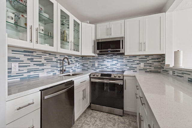 1116 Cambridge E Unit E, Deerfield Beach, FL 33442 - kitchen featuring appliances with stainless steel finishes, decorative backsplash, white cabinets, and light stone countertops