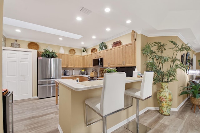 12562 Crystal Pointe Dr Unit B, Boynton Beach, FL 33437 - kitchen featuring freestanding refrigerator, light countertops, light wood-style flooring, a breakfast bar area, and light brown cabinetry