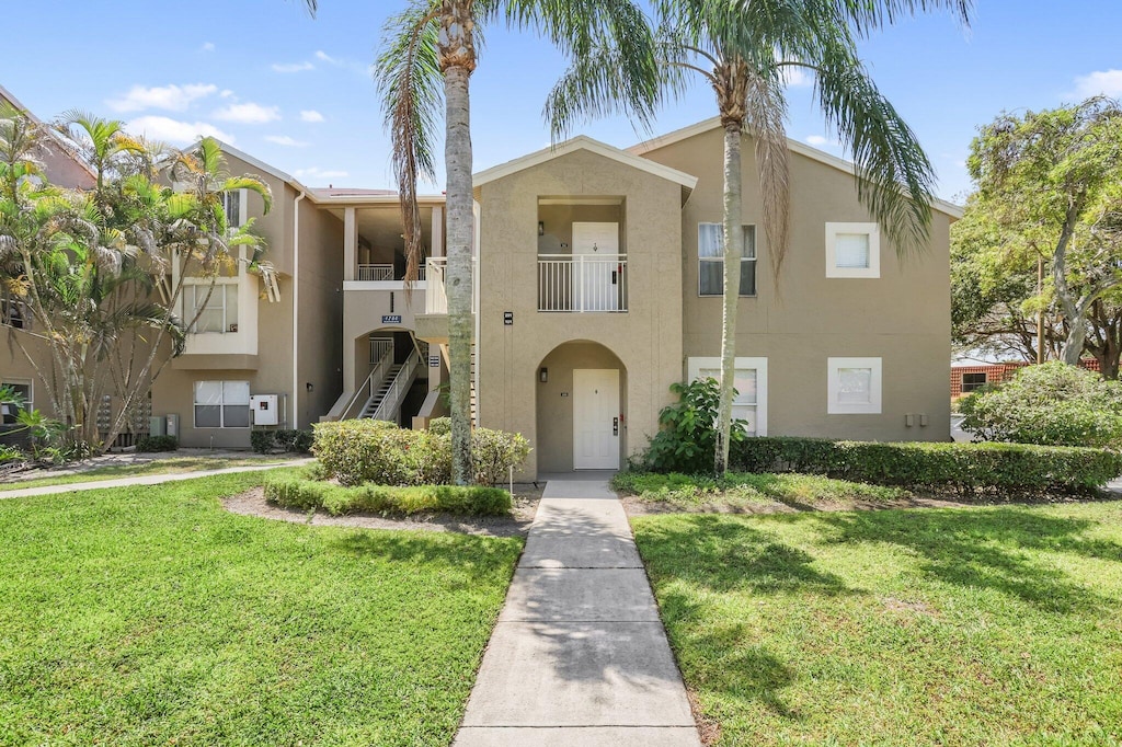 1825 Palm Cove Blvd Unit 109, Delray Beach, FL 33445 - view of front of home featuring stucco siding, a front yard, and stairway