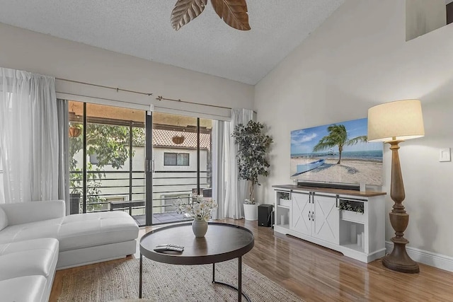 12 Via De Casas Sur Unit 203, Boynton Beach, FL 33426 - living area with wood finished floors, plenty of natural light, lofted ceiling, a textured ceiling, and a ceiling fan