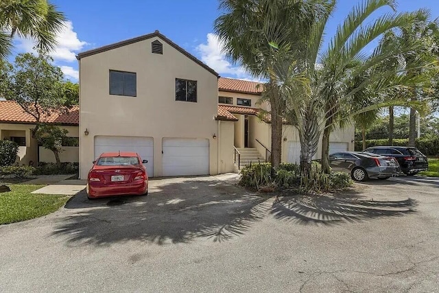 12 Via De Casas Sur Unit 203, Boynton Beach, FL 33426 - mediterranean / spanish house with a garage, a tiled roof, driveway, and stucco siding