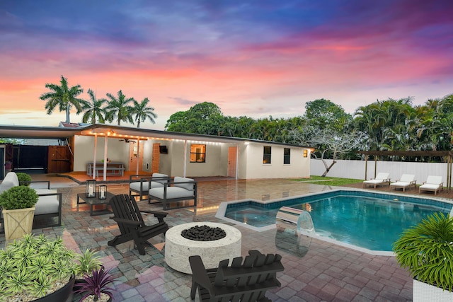 121 W Arch Dr (), Unit Lake Worth, FL 33467 - pool at dusk featuring a patio area and an outdoor living space with a fire pit