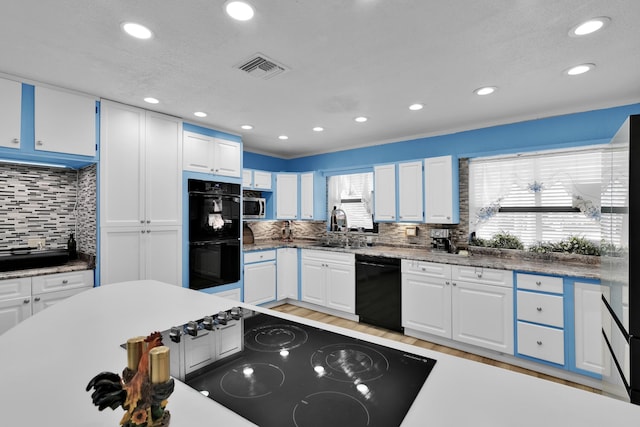 121 W Arch Dr (), Unit Lake Worth, FL 33467 - kitchen featuring black appliances, light wood-style floors, white cabinetry, backsplash, and a sink