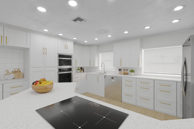 121 W Arch Dr (), Unit Lake Worth, FL 33467 - kitchen featuring stainless steel appliances, white cabinets, light stone counters, recessed lighting, and backsplash