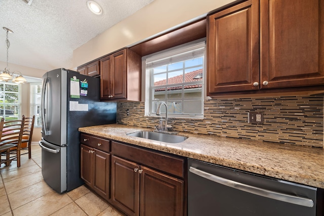 13277 Opal Ln, Wellington, FL 33414 - kitchen featuring appliances with stainless steel finishes, a textured ceiling, backsplash, light tile patterned flooring, and plenty of natural light