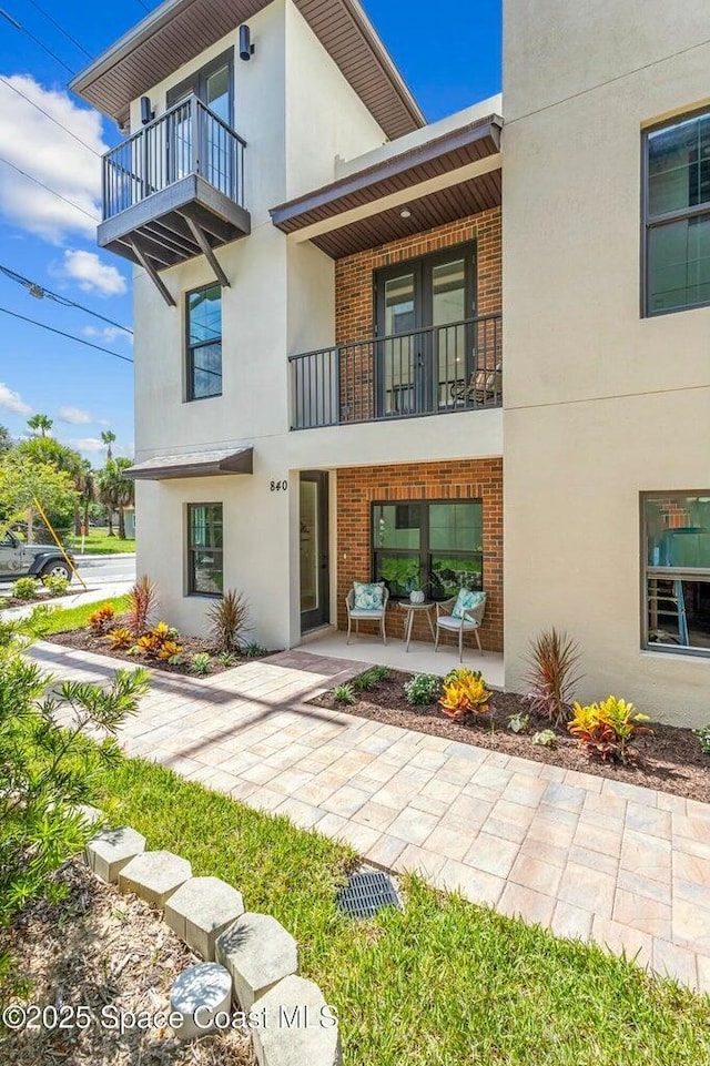 840 Florida Ave Unit 5, Cocoa, FL 32922 - rear view of property with brick siding, a balcony, and stucco siding