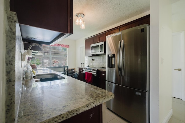 5402 Bonky Ct Unit 102B, West Palm Beach, FL 33415 - kitchen featuring appliances with stainless steel finishes, a sink, light tile patterned floors, tasteful backsplash, and light stone countertops
