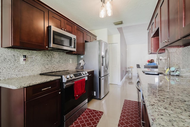 5402 Bonky Ct Unit 102B, West Palm Beach, FL 33415 - kitchen with appliances with stainless steel finishes, a sink, decorative backsplash, light tile patterned flooring, and light stone countertops
