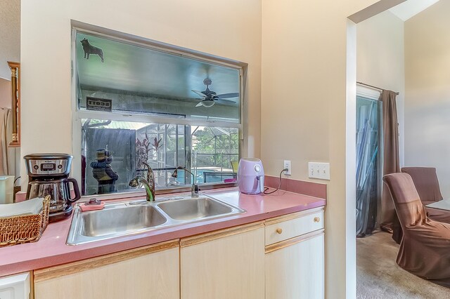 3892 SW Jablo St, Port Saint Lucie, FL 34953 - kitchen featuring a sink, light countertops, ceiling fan, and light colored carpet