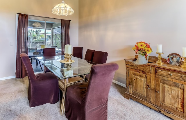 3892 SW Jablo St, Port Saint Lucie, FL 34953 - dining room with baseboards, light colored carpet, and a chandelier