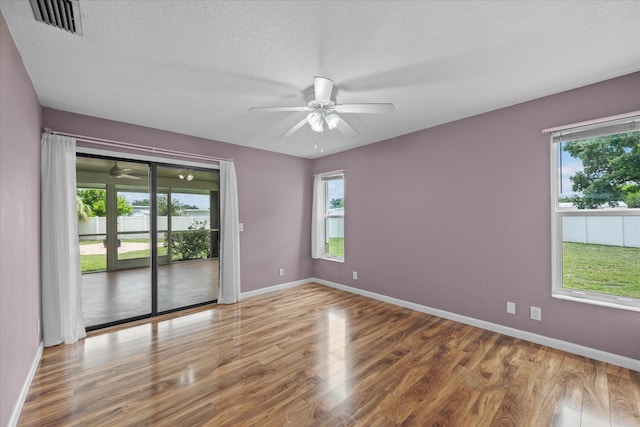 11038 Monet Ln, Palm Beach Gardens, FL 33410 - empty room with a ceiling fan, wood finished floors, healthy amount of natural light, and a textured ceiling